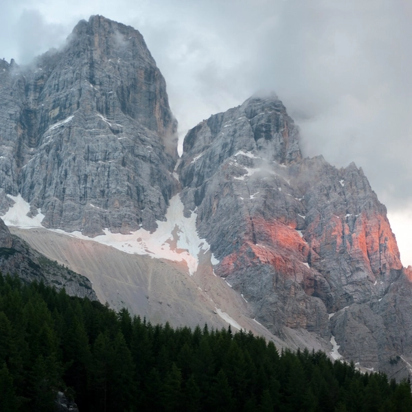 Hiker on mountain trail with jagged Dolomite peaks in background