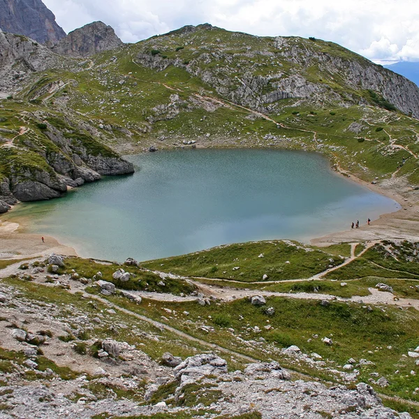 Crystal clear turquoise waters of Lago Coldai beneath towering peaks