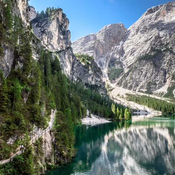 Aerial view of the turquoise Lago di Braies surrounded by dense pine forests and the Croda del Becco