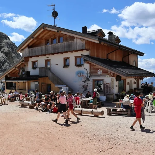Rifugio Averau sits on a rocky saddle with the dramatic peak of Averau rising behind it and views toward the Cinque Torri.