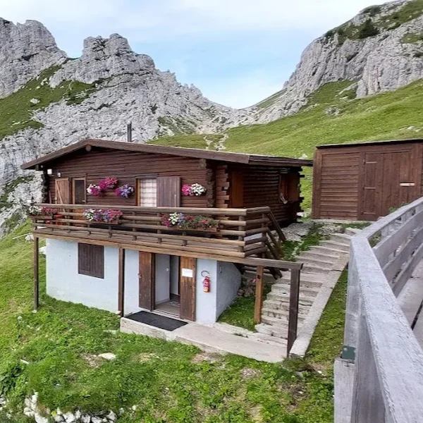The stone structure of Rifugio Coldai perched on a rocky ridge near the Civetta massif.