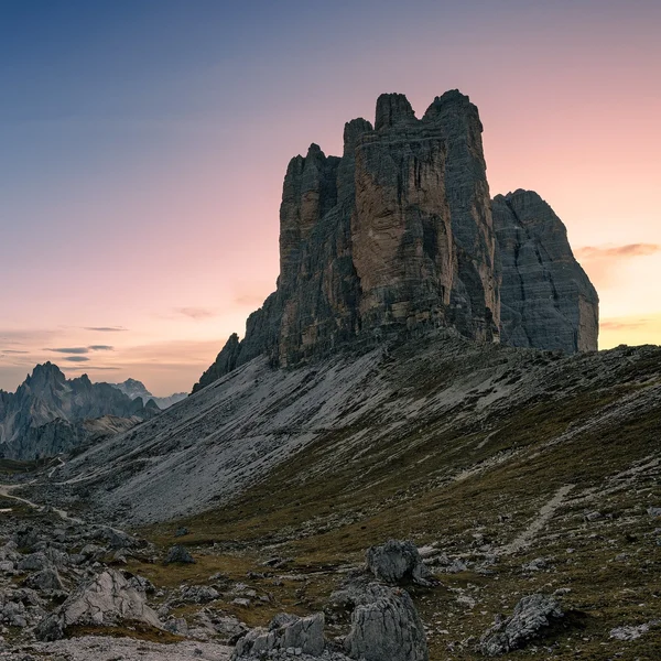 The three iconic peaks of Tre Cime di Lavaredo rising above alpine terrain